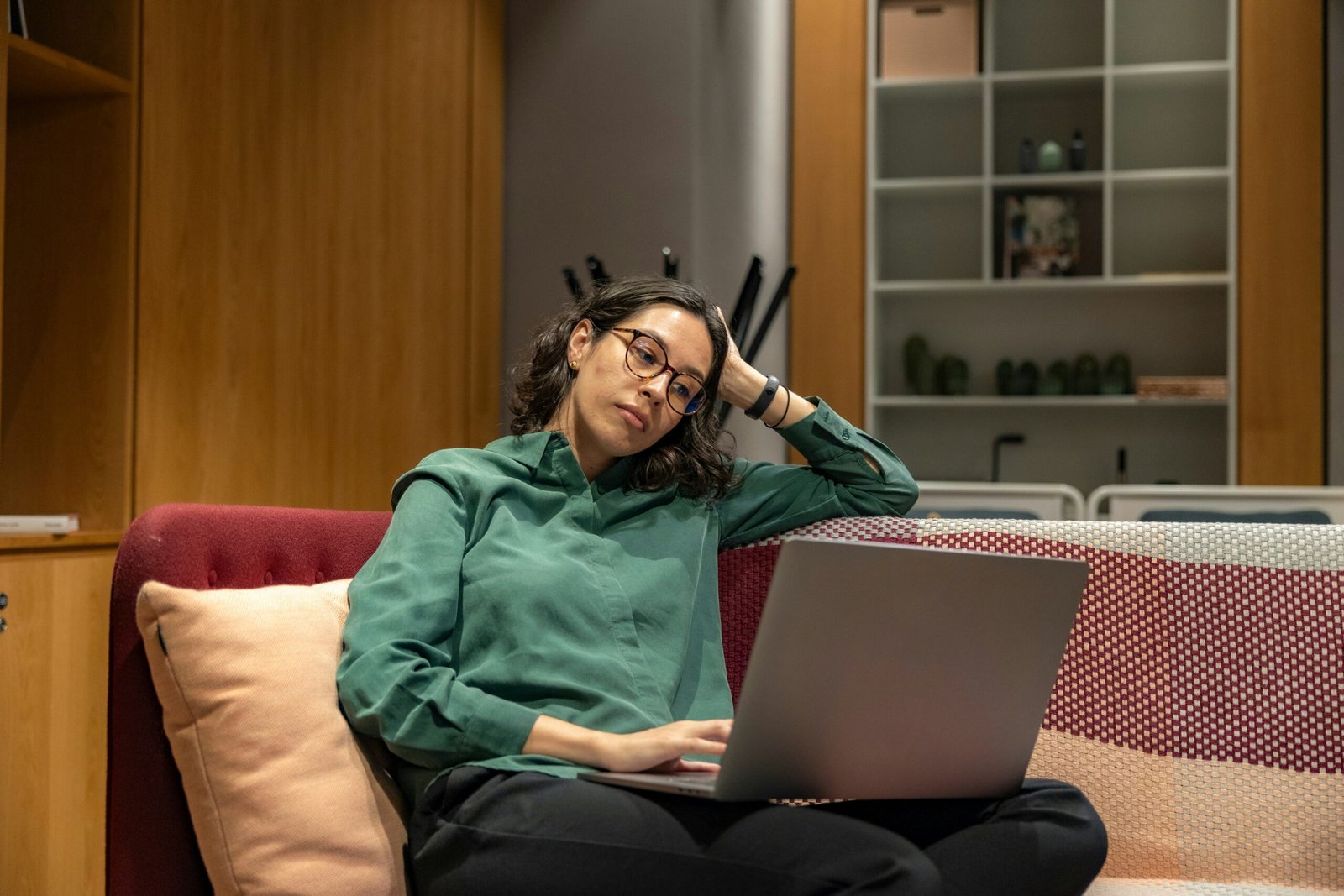 a woman sitting on a couch using a laptop computer